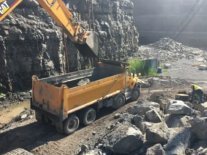 Fuite accidentelle - Consultant - Pelle mécanique chargeant des roches dans un camion benne en carrière